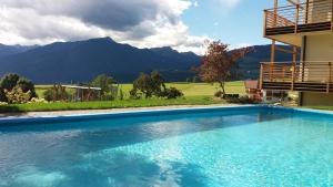 a swimming pool in front of a house with mountains at Bauernhofresidence Leierhof in Rodengo