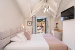a bedroom with a large bed and a television at Argostοli Bay Apartments in Argostoli