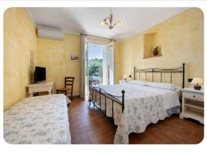a bedroom with a bed and a desk and a television at AGRITURISMO IL CARDO in Soiano del Lago +99 photos
