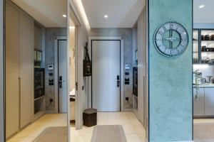 a hallway with a large clock on a wall at KRUNA 406 Luxury Sea View Apartment with Parking, Minibar, Spa & Beach - Includes 2 Complimentary Non-Alcoholic Beach Drinks & Welcome Gift in Budva