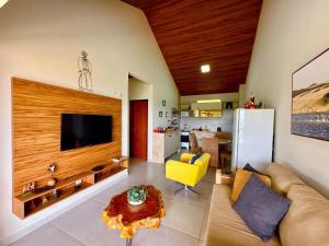 a living room with a couch and a tv and a table at dreams of the mountains in Bananeiras