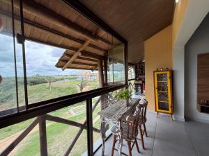 a room with a balcony with a table and chairs at dreams of the mountains in Bananeiras
