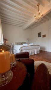 a bedroom with a bed and a table with a candle at La vie en rose in Brinay