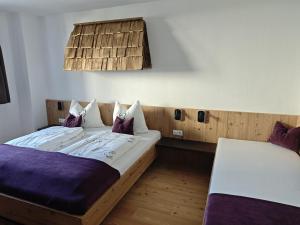 a bedroom with two beds with purple sheets at Studler-Eck in Oberperfuss