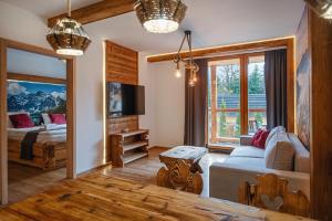 a living room with a couch and a bed and a tv at Mountain Shelter Apartments in Zakopane +74 photos