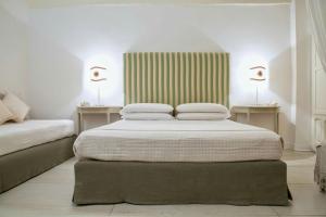 a bedroom with two beds and two tables with lamps at Domus Dejana in Gallipoli