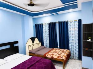 a bedroom with two beds and blue walls at Hotel Rajmahal in Ajmer +26 photos