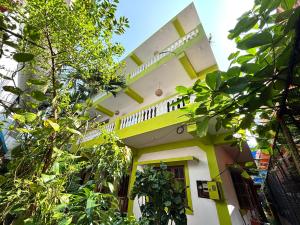 a yellow and white building with trees in front of it at Seven Summers - Mandrem in Mandrem