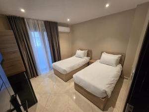 a hotel room with two beds and a television at Hotel Al Abraj in Oran +38 photos