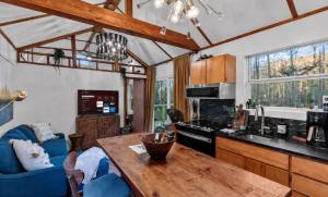 a kitchen and living room with a wooden table at Lakefront Tiny Emerald wkayaks & canoes in Shreveport
