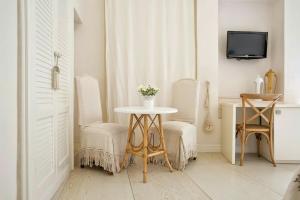 a room with a table and two chairs and a tv at Domus Dejana in Gallipoli