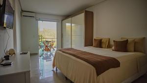 a bedroom with a large bed and a balcony at Vila Fox Estadia in Lençóis