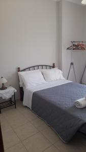 a bedroom with a large bed with a blue blanket at Βίλλα Αντρέας in Karavomylos