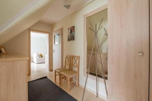 a living room with a chair and a mirror at Apartament Malinowy-Osiedle Malinowa 68, Zieleniewo in Zieleniewo