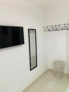 a mirror on a wall next to a tv at Plata View Center Habitacion 2D in Monte Plata +3 photos