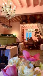 a dining room with tables and chairs and a chandelier at La vie en rose in Brinay