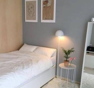 a bedroom with a bed and a table with a plant at 50 m by BTS Taladplu in Thonhuri