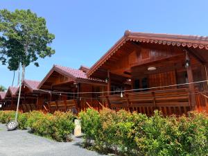 a wooden house with a tree in front of it at KT Thai House in Ban Ko Khwan