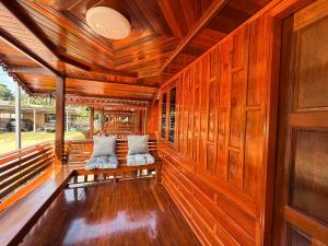 a porch with wooden walls and two pillows at KT Thai House in Ban Ko Khwan