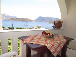 een tafel met een fruitschaal op een balkon bij Kalotina's Apartments in Emborios