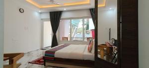 a bedroom with a bed and a large window at Hilias Retreat in Palolem