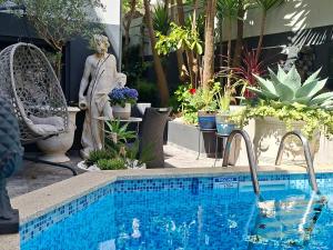 a swimming pool with a statue and some plants at alojamento maritimo II in Espinho