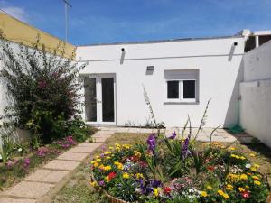 a garden with flowers in front of a white building at Atalaia Garden House in Giz