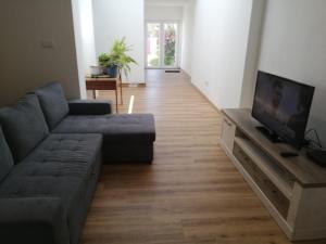 a living room with a couch and a flat screen tv at Atalaia Garden House in Giz