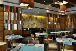 a dining room with tables and chairs in a restaurant at The Fern, Jaipur, Series by Marriott in Jaipur