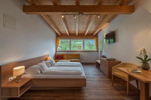 a bedroom with a bed and a desk and a window at Hotel Törggelehof in Cermes +49 photos