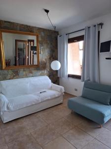 a living room with a couch and a chair at La Finestra su Stintino in Stintino