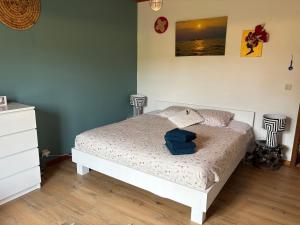 a bedroom with a bed with a blue towel on it at Chez Tantine Nadine in Couvin