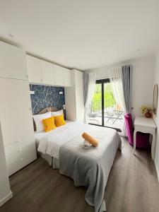 a bedroom with a large white bed with yellow pillows at Paris Dream Villa in Villejuif