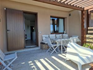 a patio with a table and chairs on a patio at La Finestra su Stintino in Stintino