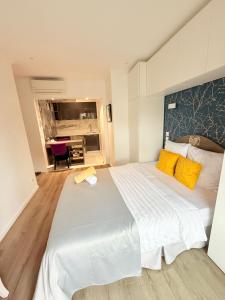 a bedroom with a large white bed with yellow pillows at Paris Dream Villa in Villejuif