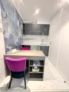a kitchen with a table and two purple chairs at Paris Dream Villa in Villejuif