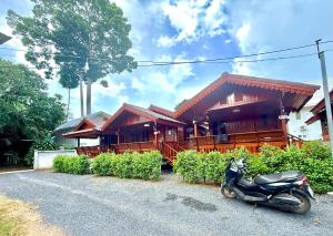 a motorcycle parked in front of a house at KT Thai House in Ban Ko Khwan