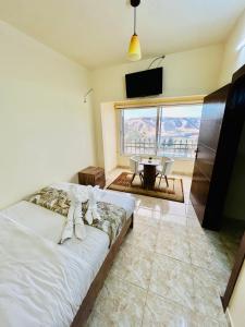 a bedroom with a bed and a table and a television at Jadara view in Irbid