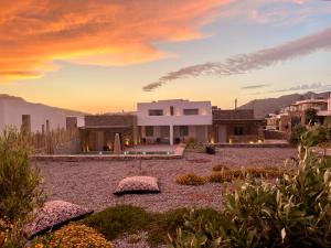 a house in the desert with a sunset at Mykonos Dot Art Homes in Ano Mera
