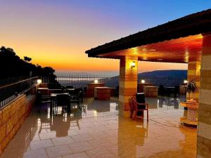 a patio with a table and chairs at sunset at Jadara view in Irbid