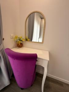 a vanity with a purple chair and a mirror at Paris Dream Villa in Villejuif