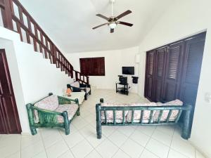 a living room with two beds and a ceiling fan at Casa Caracol Los Farallones in Cabrera