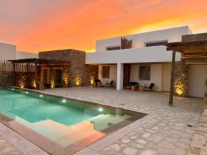 a house with a swimming pool in front of a house at Mykonos Dot Art Homes in Ano Mera