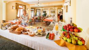 a woman standing in front of a table with food at Ametiszt Hotel Harkány in Harkány