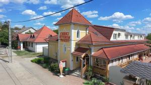 a building with a sign on the side of it at Cserki Panzió Balatonfőkajár in Balatonfőkajár