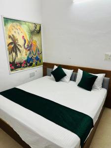 a bedroom with a large bed with a painting on the wall at Hotel park view in Bathinda
