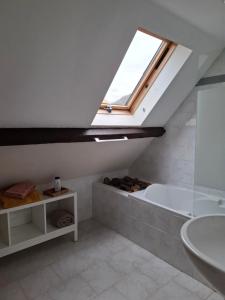 a bathroom with a bath tub and a skylight at Chez Mikki in Cassaniouze +41 photos