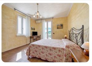 a bedroom with a bed and a table and windows at AGRITURISMO IL CARDO in Soiano del Lago
