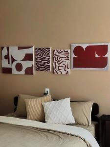 four paintings on a wall above a bed at Rémi Homestay in Thôn Văn Dương