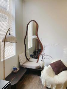 a living room with a mirror and a chair at Rémi Homestay in Thôn Văn Dương +1 photo